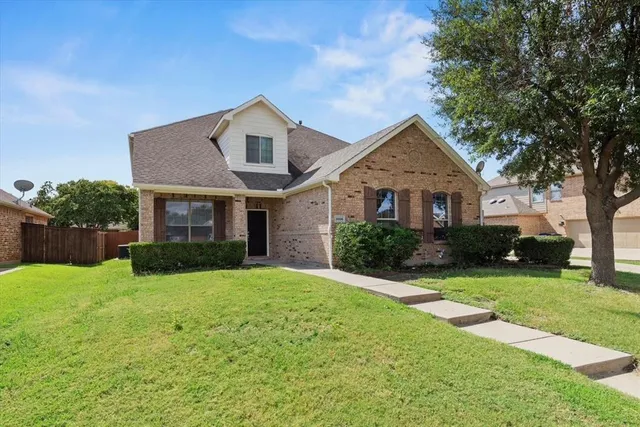 a front view of a house with yard and green space