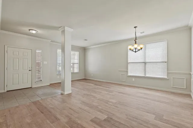 an empty room with wooden floor and window