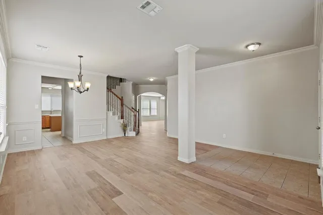 a view of empty room with wooden floor and ceiling fan