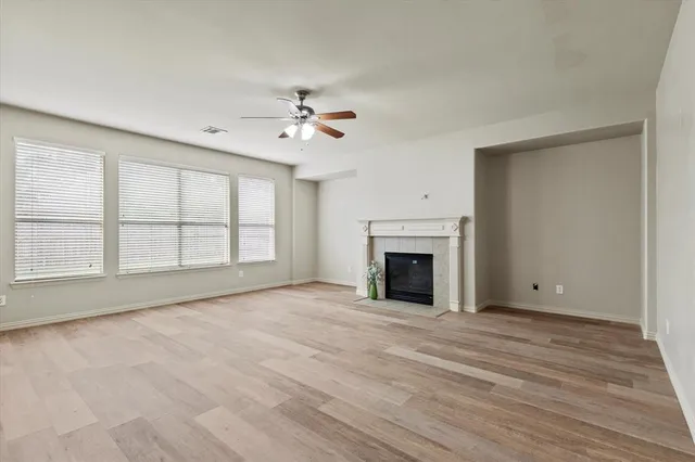 a view of an empty room with a fireplace and a window