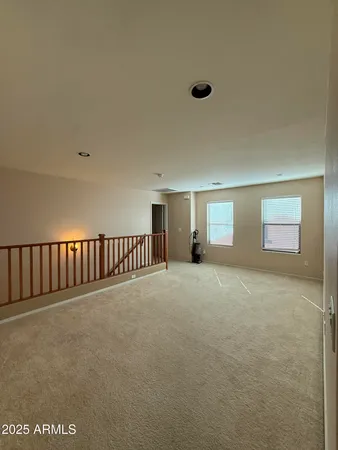 a view of an empty room with window and chandelier