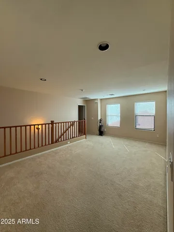 a view of an empty room with window and chandelier
