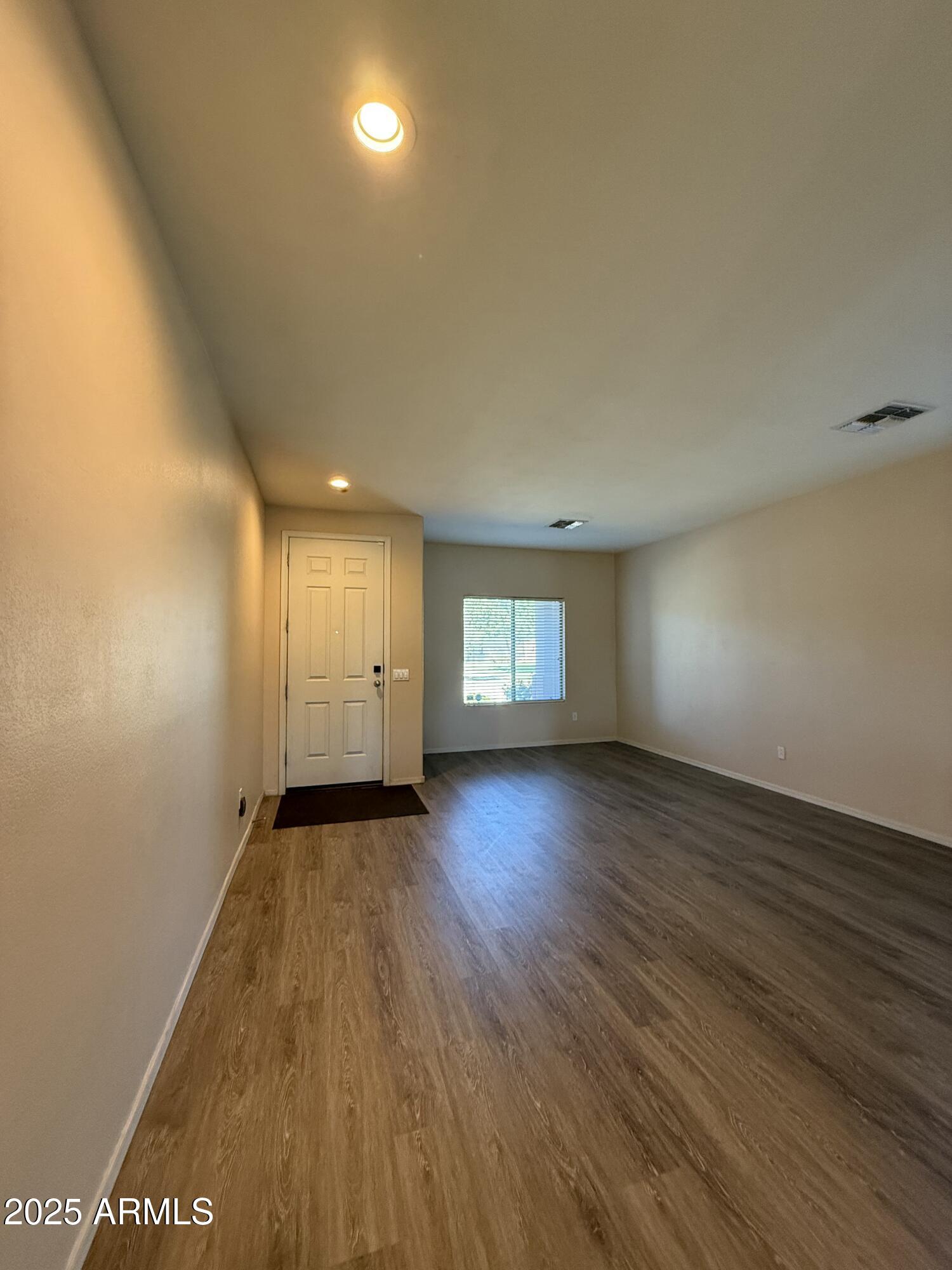 21975 East Vía Del Palo Queen Creek, AZ 85142 - Photo 2 of 19 an empty room with wooden floor and windows