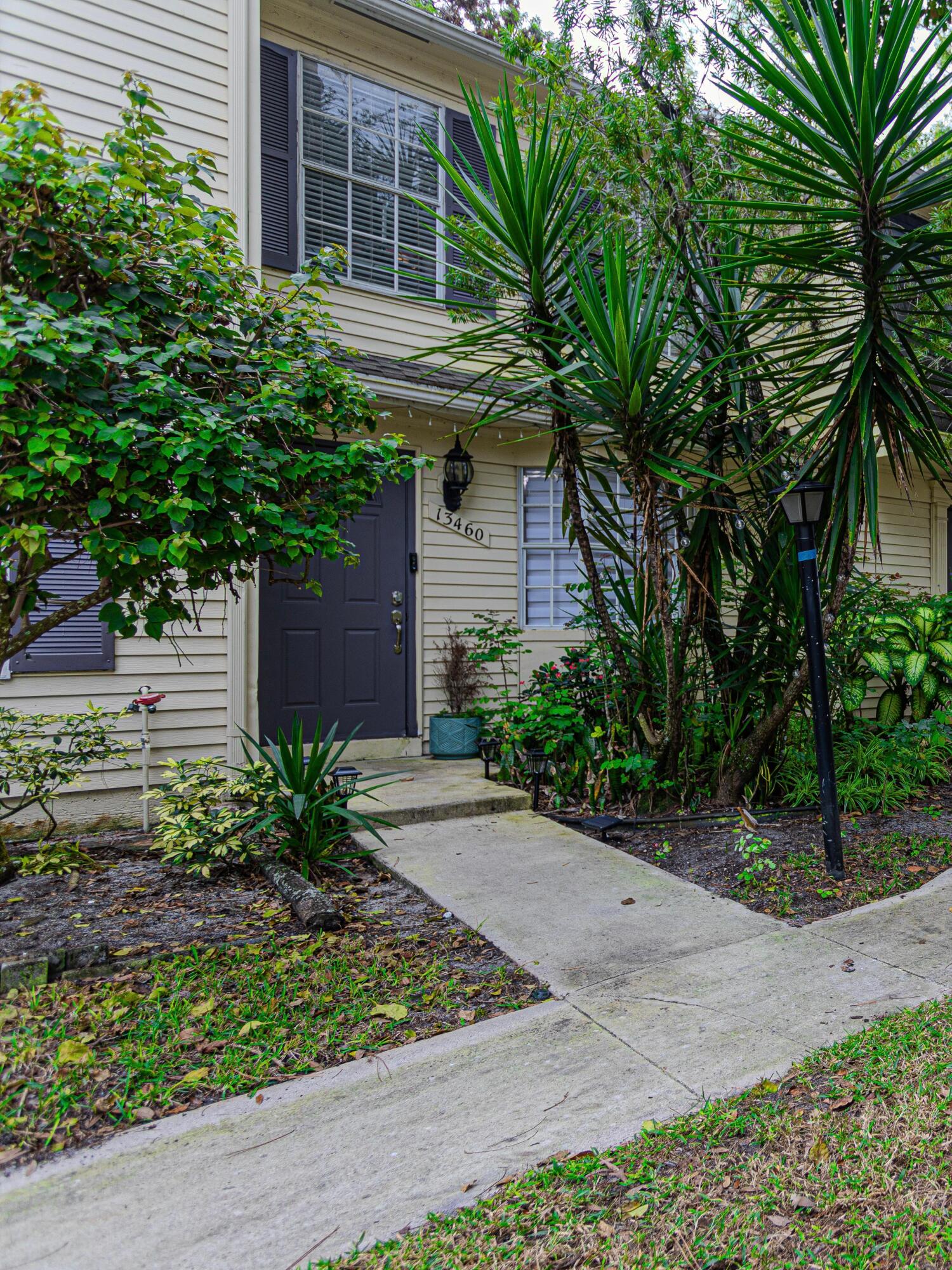 13460 Old Englishtown Road Wellington, FL 33414 - Photo 2 of 15 a front view of a house with garden