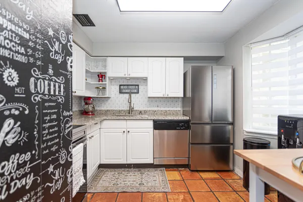 a kitchen with stainless steel appliances granite countertop a sink stove and refrigerator