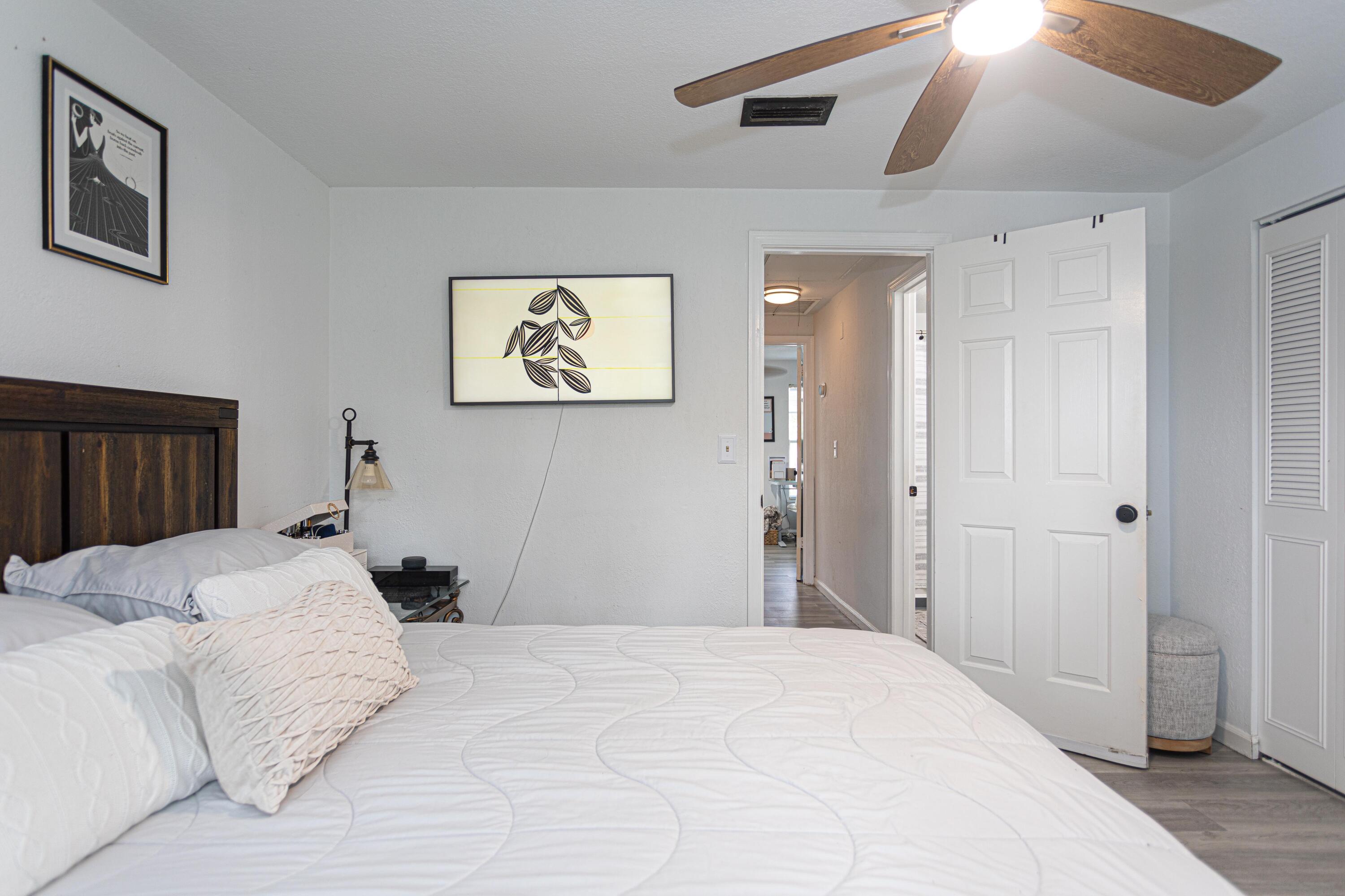 13460 Old Englishtown Road Wellington, FL 33414 - Photo 8 of 15 a bedroom with a large bed and a chandelier