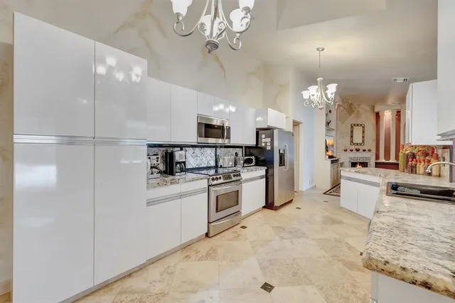 a living room with stainless steel appliances furniture a rug and a fireplace