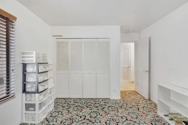 a view of a dining room and livingroom with furniture wooden floor a rug a flat screen tv and a clock