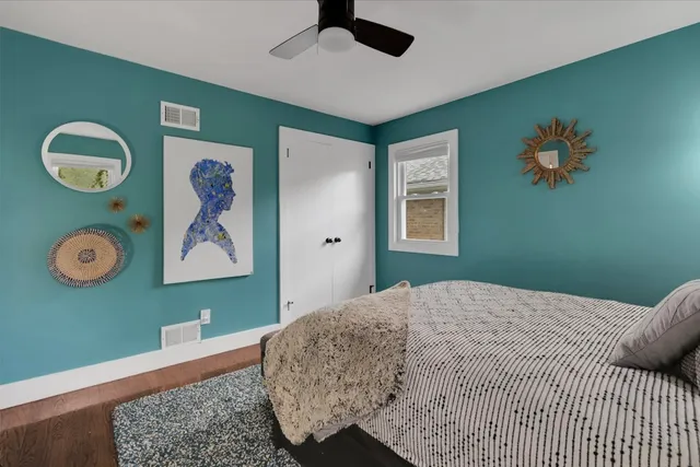 a bedroom with a bed and painting on the wall