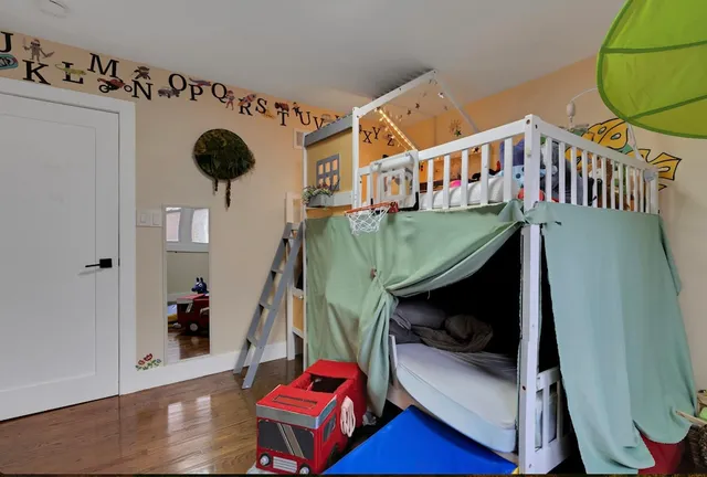 a bedroom with bunk bed and a window