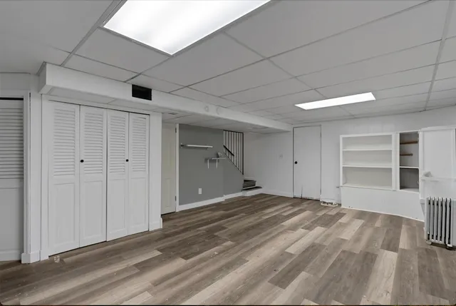 a view of empty room with wooden floor and closet