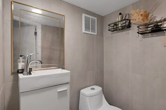 a bathroom with a sink a toilet and a mirror