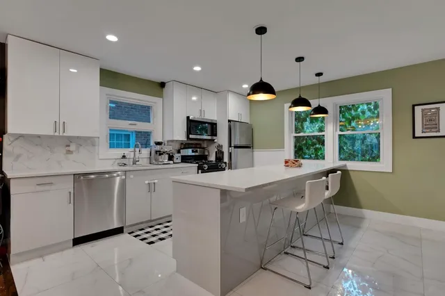 a kitchen with a sink a counter top space cabinets and stainless steel appliances