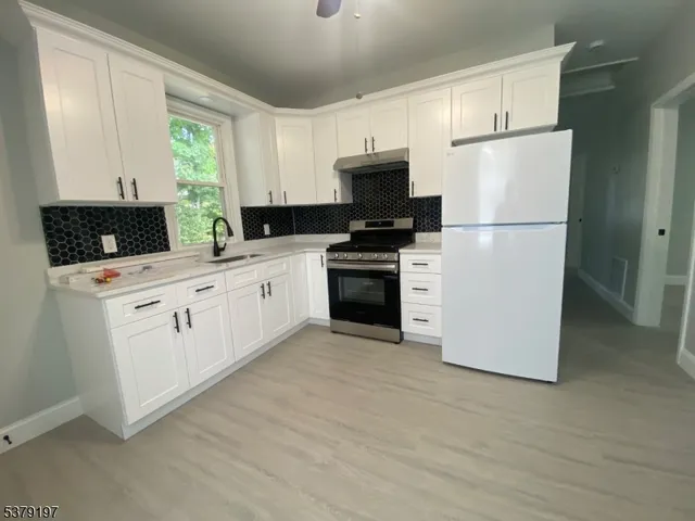 a kitchen with white cabinets and white appliances