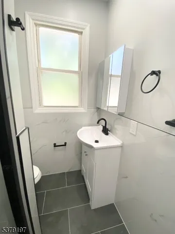 a bathroom with a sink and mirror with bathtub
