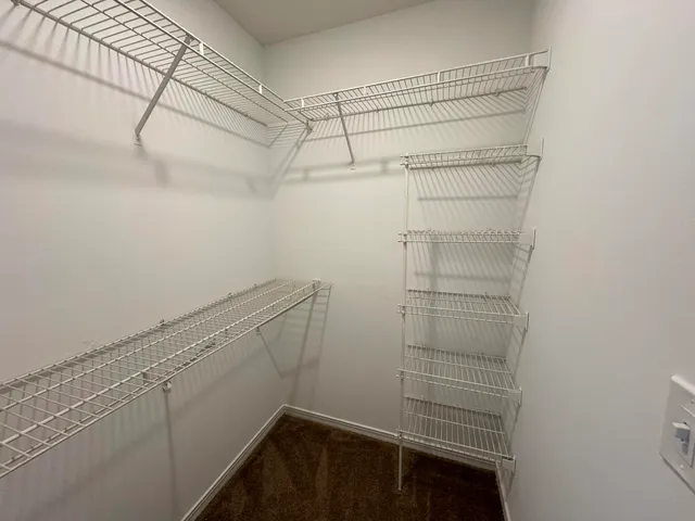 a view of walk in closet with empty racks