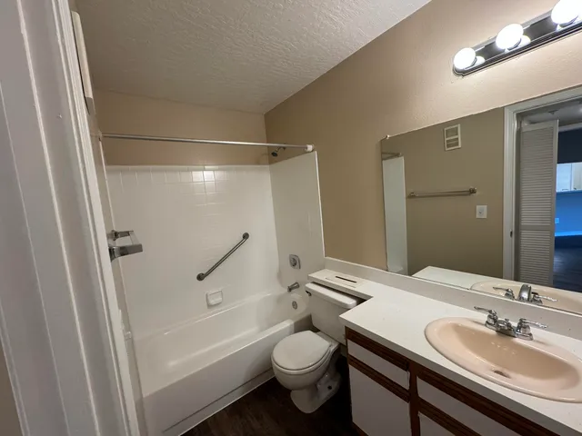 a bathroom with a granite countertop sink toilet and shower