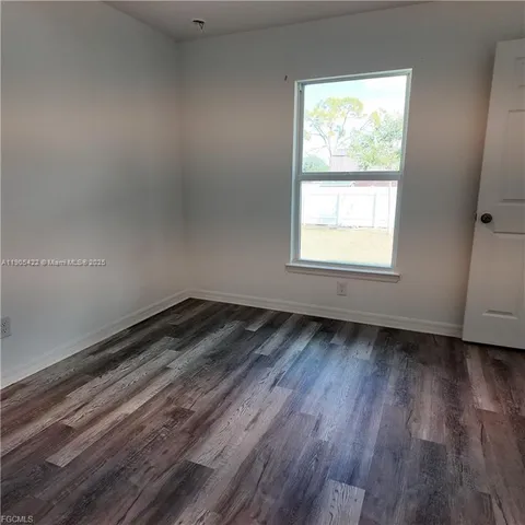 a view of a room with wooden floors and window