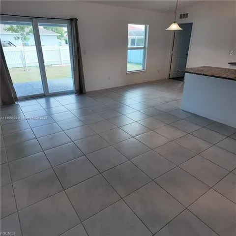 a large white kitchen with a sink and dishwasher a stove top oven with wooden floor