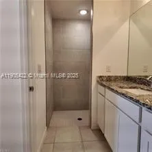 a bathroom with a granite countertop shower and a sink