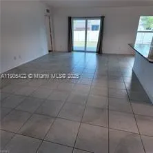 a view of a livingroom with wooden floor and a window