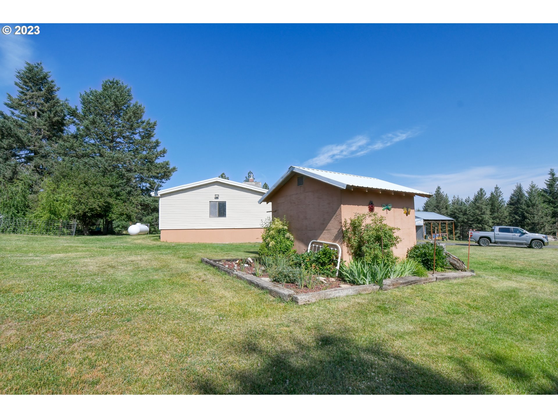 49414 County 1028 Road Pendleton, OR 97801 - Photo 14 of 48 a backyard of a house with plants and a garden