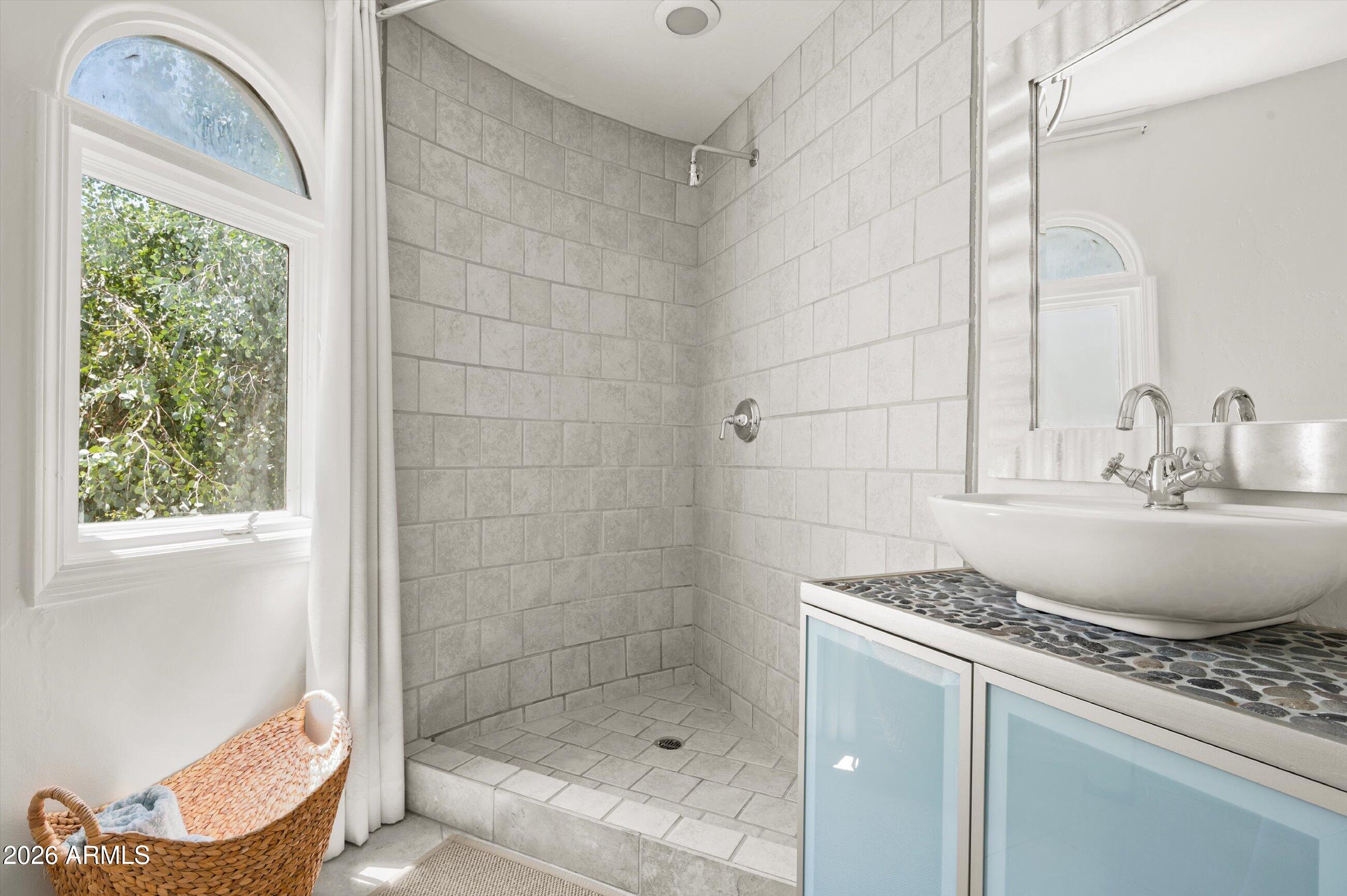 4955 East Indian School Road, Unit 9 Phoenix, AZ 85018 - Photo 17 of 25 a bathroom with a granite countertop sink a mirror and shower