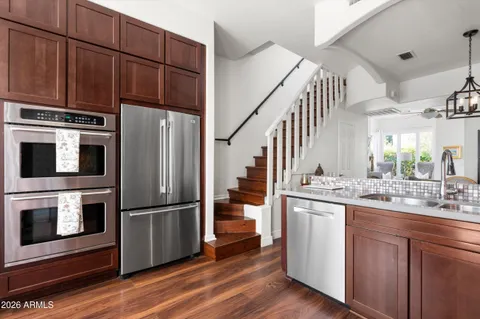 a kitchen with stainless steel appliances kitchen island granite countertop a refrigerator and a stove top oven