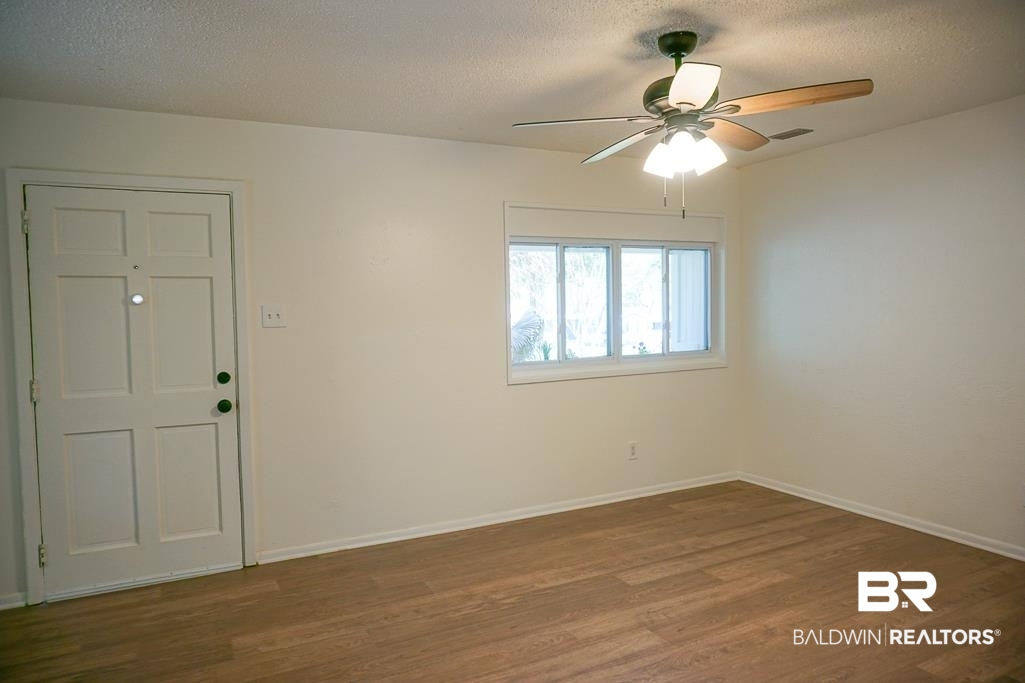 4159 Rebecca Road Mobile, AL 36609 - Photo 4 of 19 Spare room with visible vents, a textured ceiling, baseboards, and wood finished floors