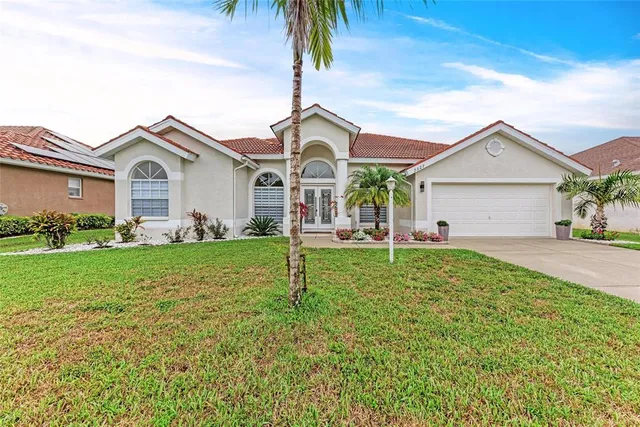 a view of a house with a yard and potted plants