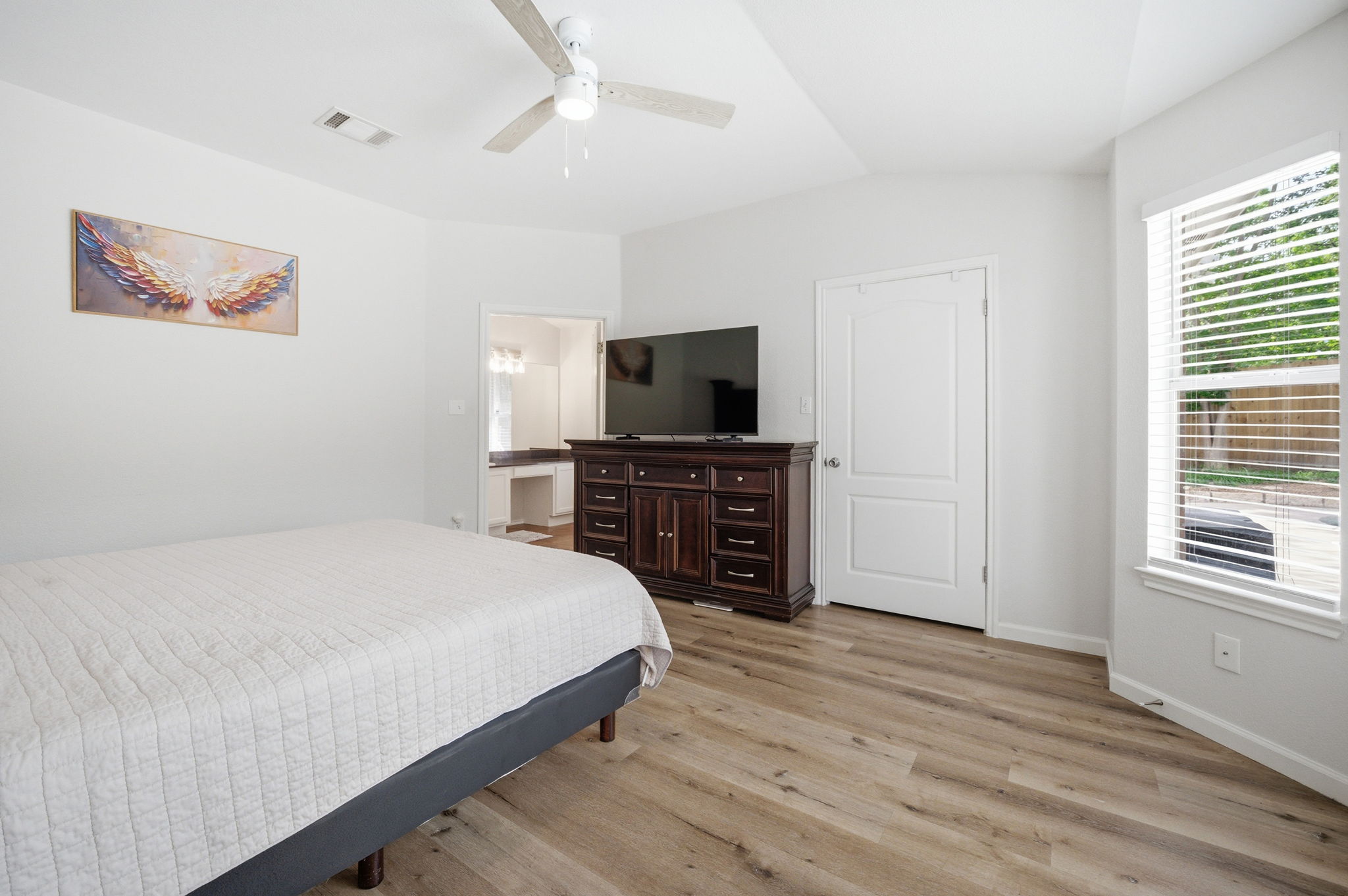 9024 Heiden Lane Austin, TX 78749 - Photo 15 of 28 Vaulted ceiling bedroom featuring wood-finish flooring, a ceiling fan, and a large window with blinds