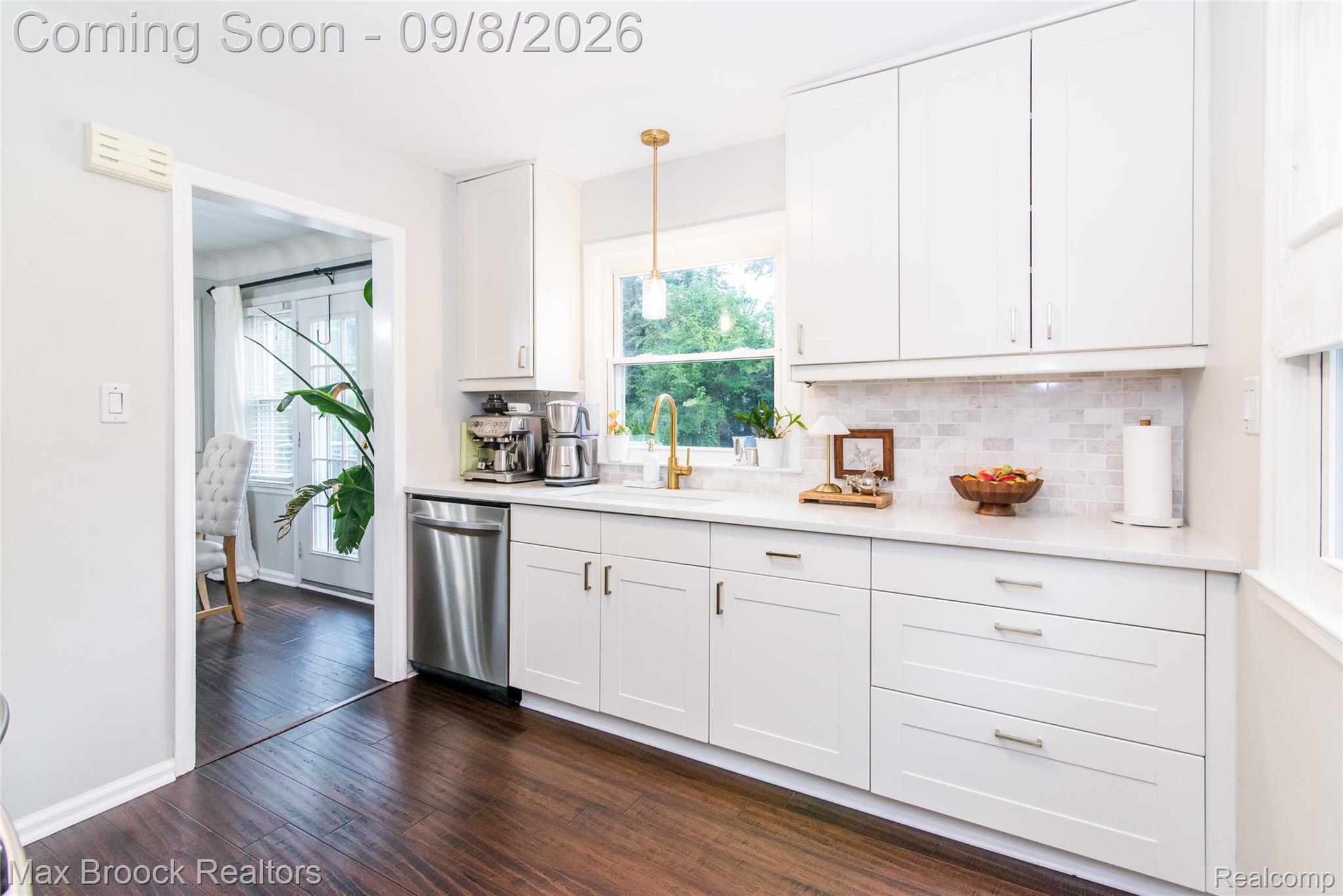 1533 Mansfield Road Birmingham, MI 48009 - Photo 15 of 48 White shaker-style cabinetry, stainless steel dishwasher, light-toned backsplash, wood-finish flooring, and a gold-tone faucet
