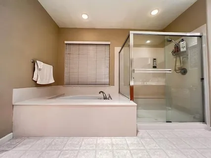 a bathroom with a bathtub sink and mirror
