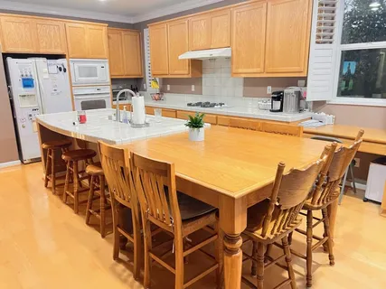 a kitchen with stainless steel appliances a sink a stove a table and chairs