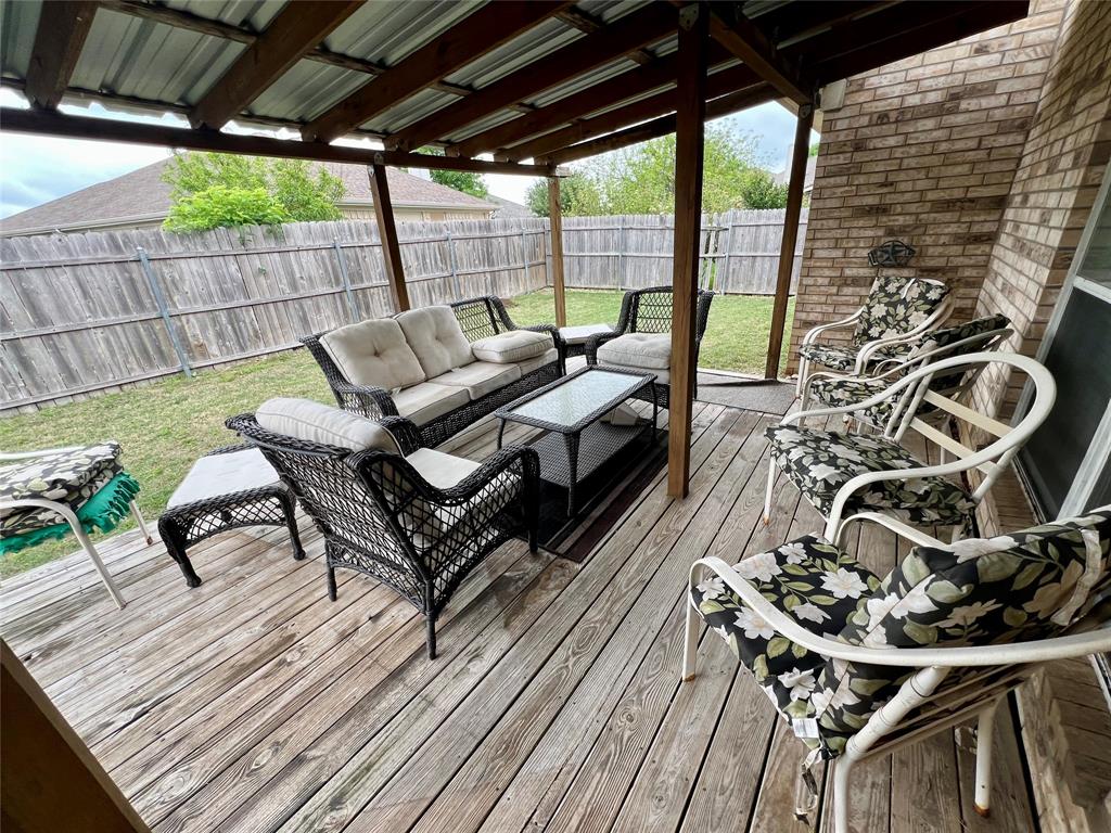 12201 Rolling Ridge Drive Fort Worth, TX 76028 - Photo 19 of 21 Covered outdoor deck with exposed wood framing and a metal roof