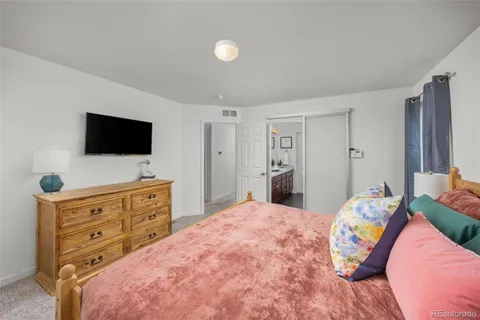 a bedroom with a bed and flat screen tv