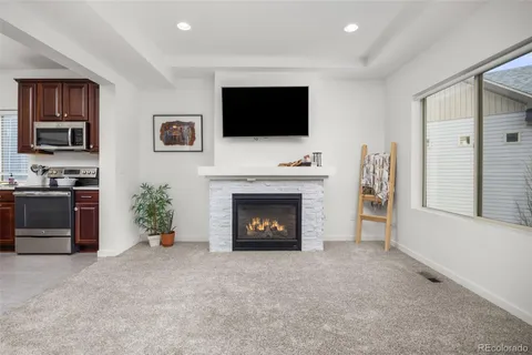 a living room with furniture a fireplace and a flat screen tv