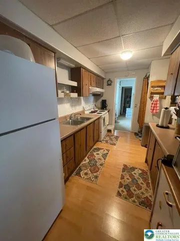 a kitchen with stainless steel appliances granite countertop a refrigerator a stove and a sink