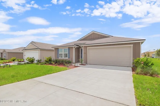 a front view of a house with yard and green space