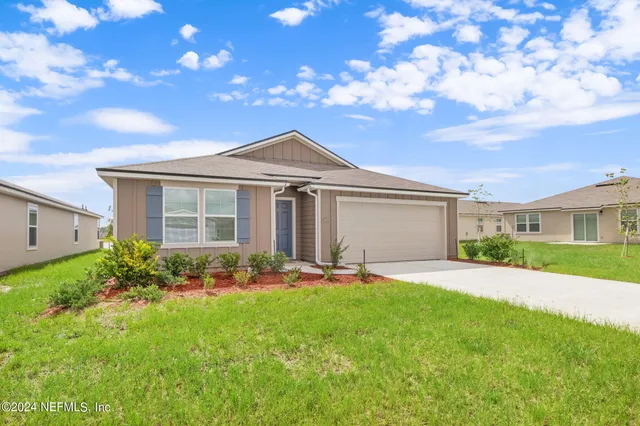 a front view of a house with a garden and yard