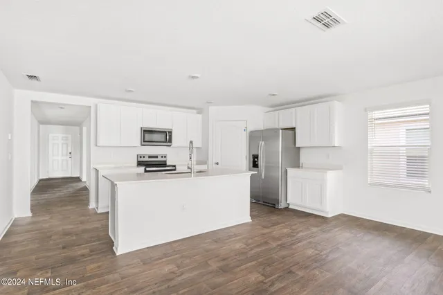 a kitchen with stainless steel appliances a refrigerator and a stove top oven