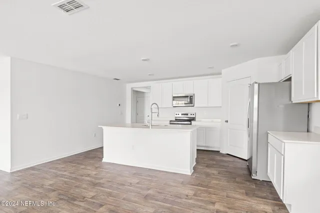 a kitchen with stainless steel appliances a sink and a refrigerator