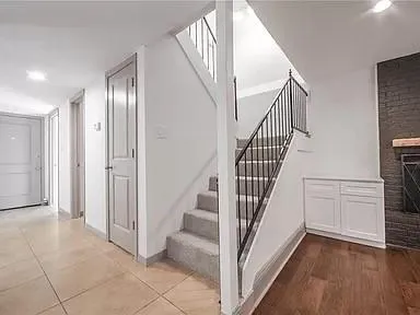 a view of a hallway with entryway wooden floor and staircase