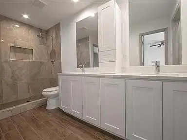 a bathroom with a toilet a sink and mirror