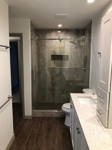 a bathroom with a granite countertop sink toilet and shower
