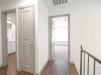 a view of a hallway with wooden floor