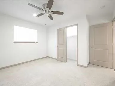 an empty room with a ceiling fan and a window