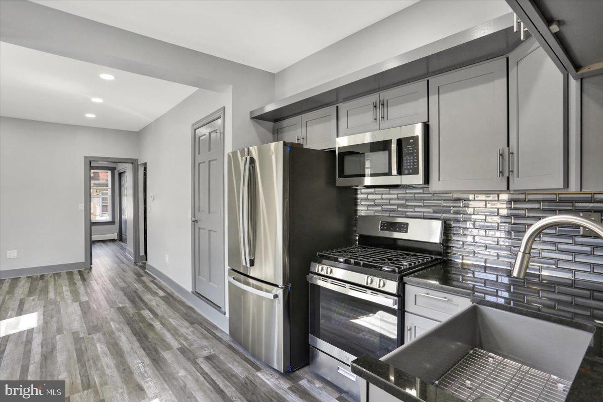 553 Wunder Street, Unit 2 Reading, PA 19602 - Photo 6 of 20 a kitchen with granite countertop a refrigerator and a stove top oven
