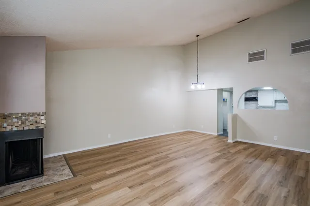 a view of empty room with wooden floor