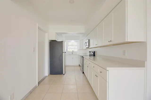 a kitchen with cabinets and a refrigerator